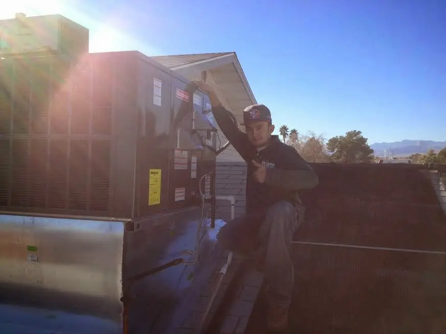 HVAC technician performing AC Tune-Up on a rooftop unit in Montevallo